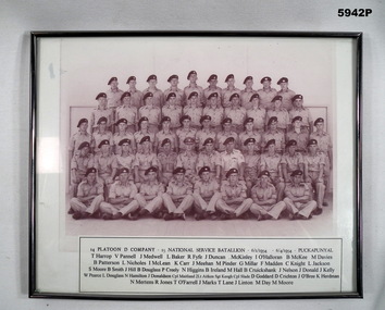 Framed photograph with caption of a group of soldiers in uniform.