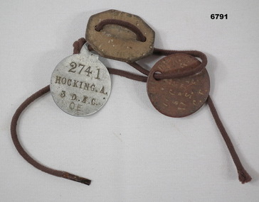Three identity discs on leather strap.