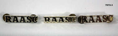 Three gold coloured metal RAASC shoulder board badges.