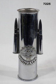 Trench art featuring a shell, two bullets and a Rising Sun badge.