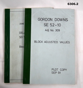 Blue covered booklets green tape binding containing data values for Block adjustment.