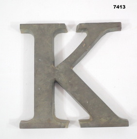 Brass letter "K" from Sandakan Memorial.