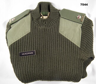 Jungle green woollen jumper with shoulder boards and officer's insignia.