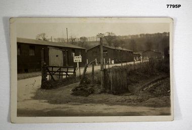 Black and white photograph of a series of buildings fronting a road.