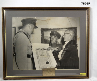 Framed photograph of a presentation ceremony.