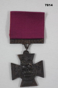 Replica Bronze medal with attached maroon ribbon.