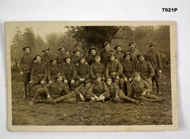 Black and white photographic postcard featuring a group of WW1 Australian soldiers in uniform.