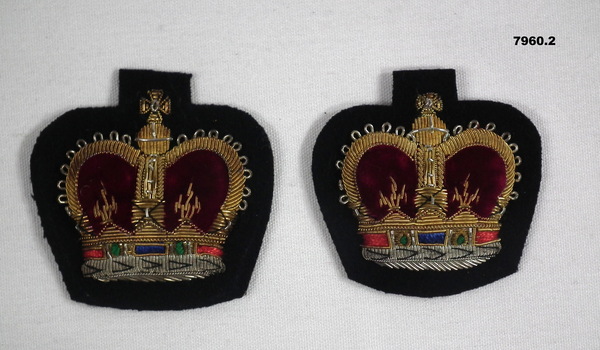 Two WO2 Queen's Crown Insignia on a black background.