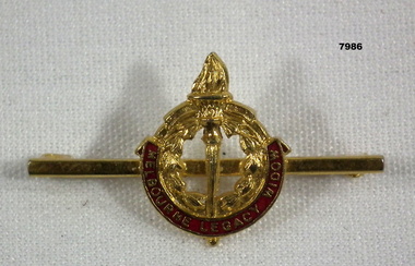 Gold coloured Legacy badge with pin.