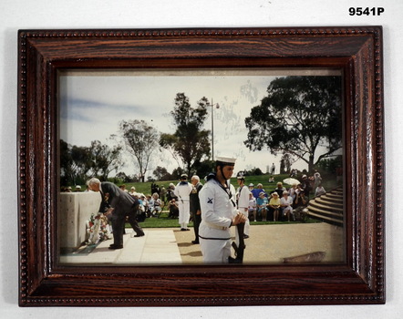 Framed photo of a wreath laying ceremony.