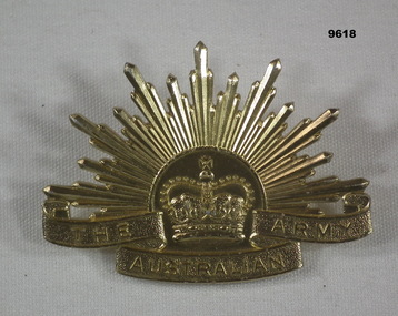 Gold coloured metal Rising Sun hat badge.