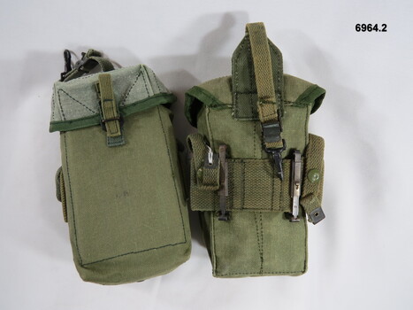 Two ammunition pouches fitted with multiple webbing attachments.