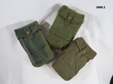 Three rectangular utility ammunition pouches with brass attachments.