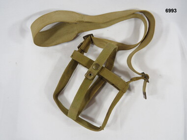 Khaki webbing harness for a water bottle.