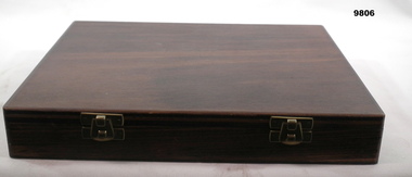 dark wooden box containing samples of gold colour standards - closed box