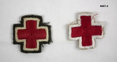 Two badges with red cross on white edging.