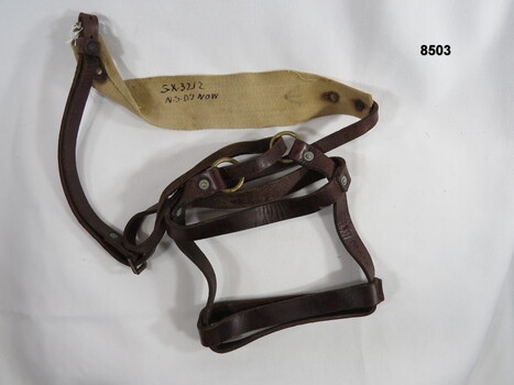 Leather water bottle harness with shoulder strap.
