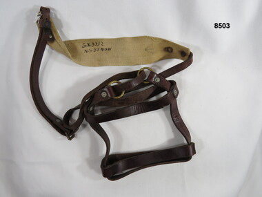 Leather water bottle harness with shoulder strap.