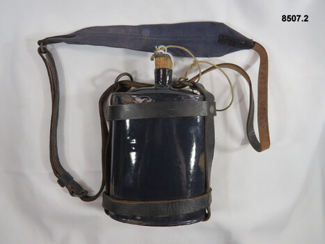 Blue enameled water bottle and leather harness.