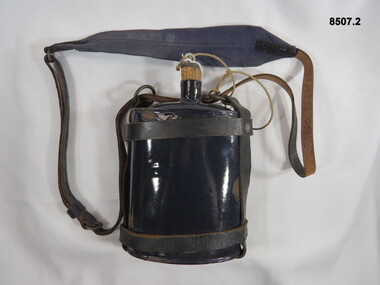 Blue enameled water bottle and leather harness.