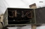 A metal storage case with carrying strap for a Survey Instrument with two mirrors