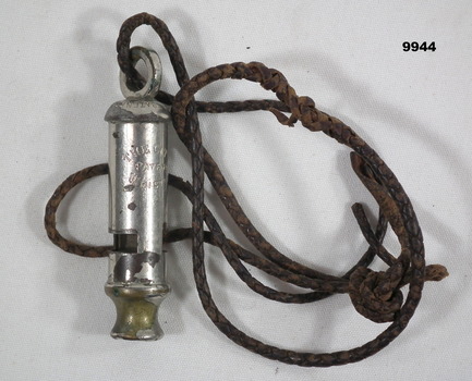 Silver coloured metal whistle with plaited leather cord.