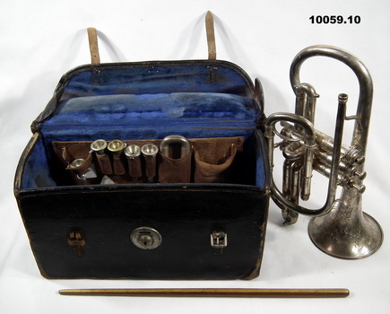Brass musical instrument with case and accessories.