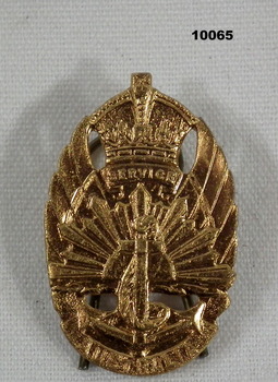 Gilded brass badge featuring symbols of the three services.