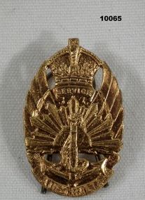 Gilded brass badge featuring symbols of the three services.