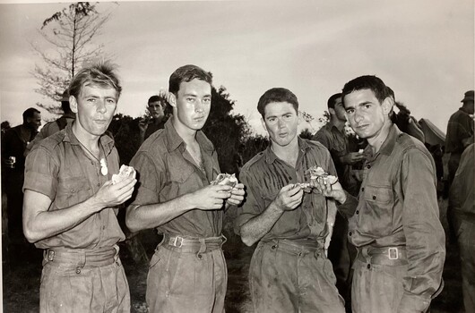 Four soldiers taking a break with food.