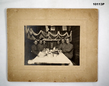 Group of six men at a table - black and white photograph.