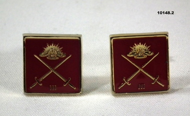 Pair of gold and maroon coloured cuff links with Army insignia.