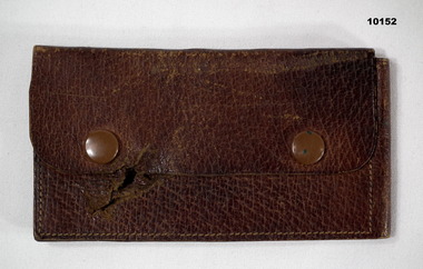 Brown leather wallet with shrapnel damage.