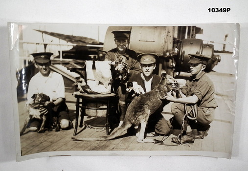 A WW1 Transport Ship with Ships Mascots being held by four servicemen