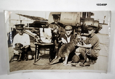A WW1 Transport Ship with Ships Mascots being held by four servicemen