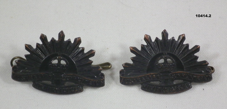 Two Rising Sun Lapel badges.