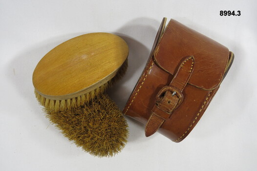Leather case to hold two grooming brushes.