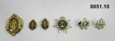 Various military badges of different sizes.