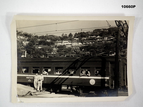Black and white photograph of a train carriage with Army personnel.