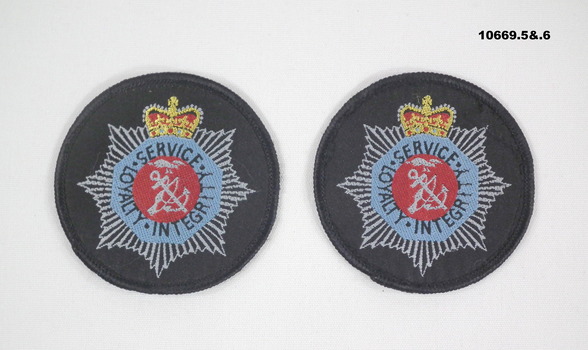 Pair of cloth badges with Corps of Commissionaires logo.