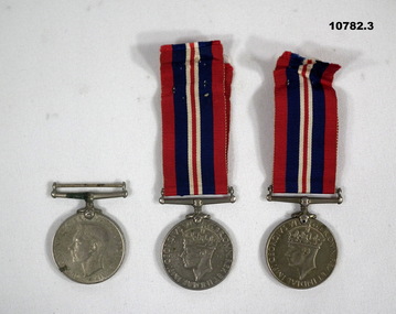 Three medals, one without ribbon.