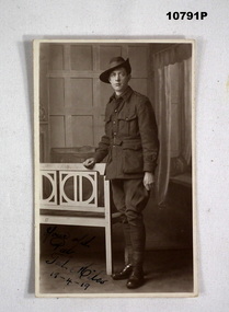 Photographic postcard featuring a WW1 soldier in uniform.
