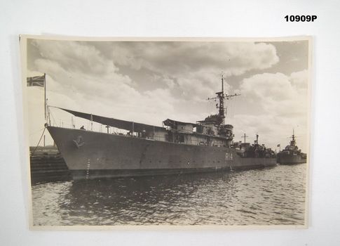 Black and white image of a ship tied to a wharf.