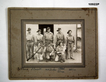 Group photograph of eight soldiers in training fatigues.