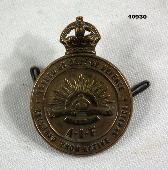 Round Bronze coloured badge - Returned from Active Service.