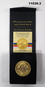 Gold coloured medal marking the 60th Anniversary of the end of WWII.
