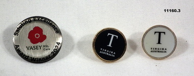 Three round metal and enamel lapel badges.