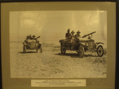 Framed B&W photo of two Model T Ford vehicles, with crew, fitted with a Lewis Machine Gun