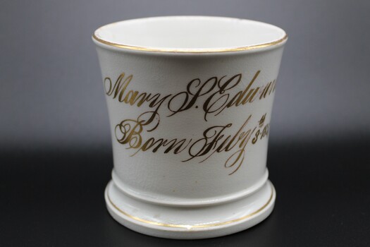 A small child's cup or mug with one handle.