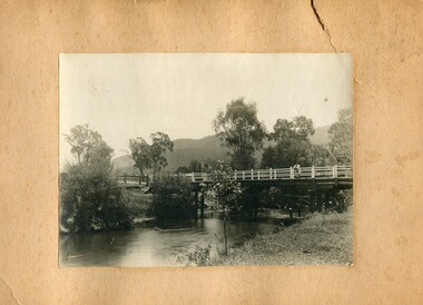 Photographs- 1 old black and white photograph of a wooden bridge over a river possibly Ryders Bridge in Tawonga. 2 –Enlargement of the original photograph showing the gentleman leaning on the bridge. Taken off the original photo